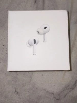 Apple AirPods Pro 2 USB-C - Säljer ett par Apple AirPods Pro (2nd Generation) med MagSafe-laddningsetui och USB-C. Hörlurarna är vita, trådlösa in-ear-modeller med stilren design och silikonproppar för bra passform. Perfekta för musik, samtal och brusreducering.