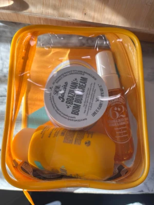 Sol de Janeiro Bum Bum Summer Jet Set (aldrig använd!) - Set med tre produkter från Sol de Janeiro i en gul necessär: Brazilian Crush Cheirosa 62 Perfume Mist (30 ml), Brazilian 4 Play Moisturizing Shower Cream-Gel (90 ml) och Brazilian Bum Bum Cream (50 ml). Perfekt för resan och ger en tropisk doft och återfuktad hud.