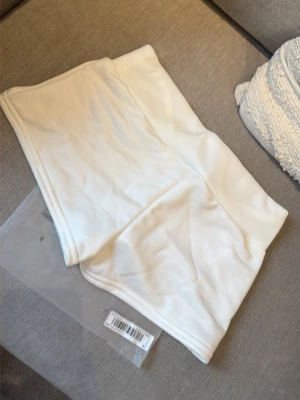 Nya i förpackning! Vita shorts med tryck och snörning - Säljer ett par vita shorts med snörning i midjan och tryck med texten 'California Los Angeles' framtill. Shortsen har en sportig vibe och är perfekta för varma dagar. Mjukt material och relaxed fit.