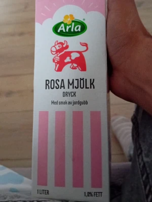 Arla rosa mjölkdryck jordgubb - En liter rosa mjölkdryck från Arla med smak av jordgubb. Förpackningen är vit och rosa med en röd ko och grönt Arla-märke. Innehåller 1,0% fett och har en söt, bärig smakprofil.