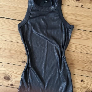 Glittrig tanktop - En mörkare gråglittrig tanktop! Sitter så fint på, perfekt längd och kramar väldigt smickrande. Otroligt passande för festligare tillställningar då den glittrar så! Aldrig använd. Hör av dig vid frågor eller behov av fler bilder💕