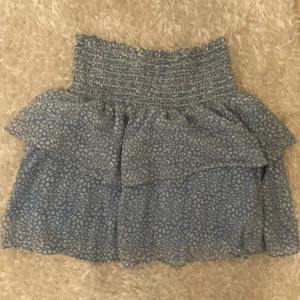 Chelsea-kjol - Vitmönstrad blå volangkjol från Chelsea i storlek M. Använd men i mycket bra skick