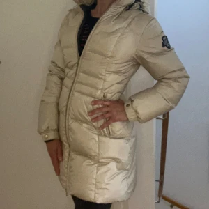 Exklusive dunjacka  - Exklusive 8848 Altitude dunjacka i champagne med avtagbar huva. Välhållen, snygga linjer, figursydd och tidlös. Otroligt varm på vintern, även med svenska fjällens låga temperaturer.