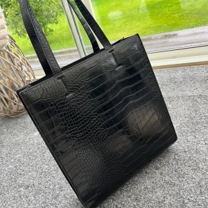 Svart handväska   - Fin handväska i svart skinn som rymmer laptop, knappt använd 