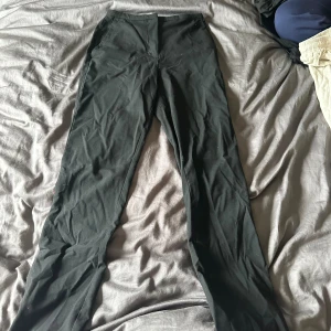 Svarta byxor från H&M - Ett par svarta kostymbyxor från H&M i storlek 34. Byxorna har en enkel design och är tillverkade i ett mjukt och bekvämt material.