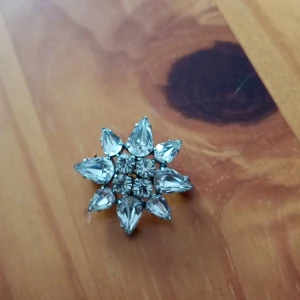 Brosch mönstrad silverfärgade med vita stenar stjärna. - Vacker brosch mönstrad silverfärgade med vita stenar stjärna.
