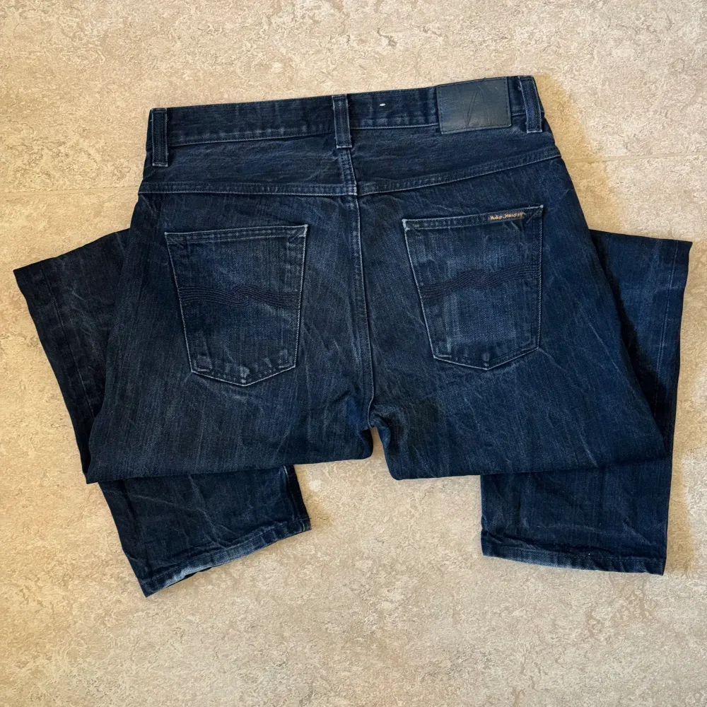 Nudie Jeans i modellen Sleepy Sixten och färgen ”Dry Black Selvage”, använda till en snygg wear och i gott skick. Storlek: 32 W, 32 L , Midja: 41.5 cm Ytterben: 103.5 cm Benöppning: 19 cm. Jeans & Byxor.