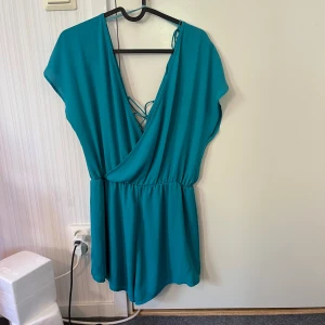 Jumpsuit / klänning - Ser ut som turkosfärgad klänning, men är en jumpsuit med topp och lösa shorts. Jätte bekväm och söt. Perfekt när de varmt, man råkar inte visa för mycket då det är shorts. Går att justera hur lös den ska vara när man knyter snörena på ryggen.