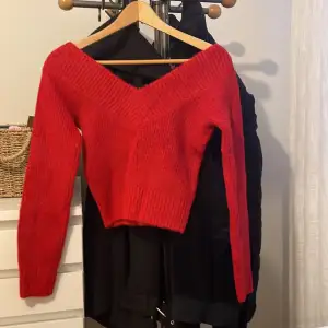 Röd stickad tröja som aldrig kommit till användning 