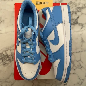 Nike Dunk Low UNC (2024) Juniormodellen  - Sommarens fräschaste sko!  Helt nya och oanvända. Storlek: 38.5 Pris: 900+frakt. Handla tryggt hos oss med massor av nöjda kunder. Skicka ett meddelande vid intresse. 