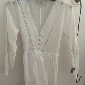 Klänning - Jätte fin klänning som har detaljer och broderat tyg. Den är tajtare vid midjan och har knappar där fram. Från zara