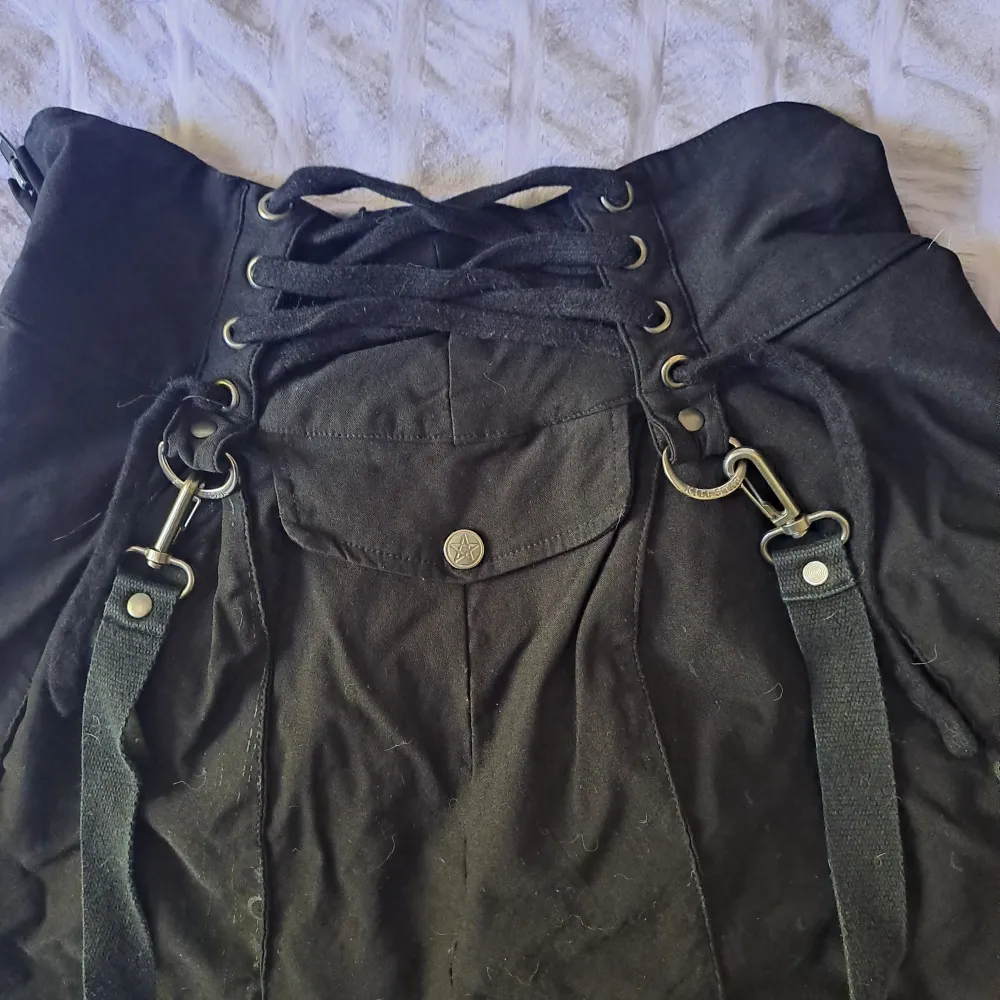 Used item but still in very good condition. Straps on each side and string to loosen or tighten skirt. Zipper in the back . Kjolar.