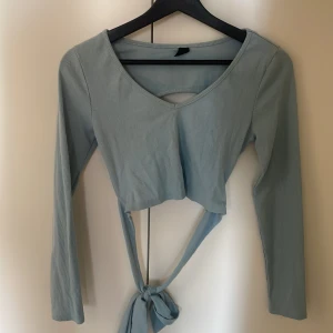 Ljusblå Tröja med öppen rygg - Blå tröja med öppen rygg. Superbra skick, används inte längre 