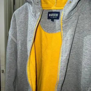 Grå tjock hoodie med gul insida från James Harvest Sportswear. Storlek XL. Jättefint skick.