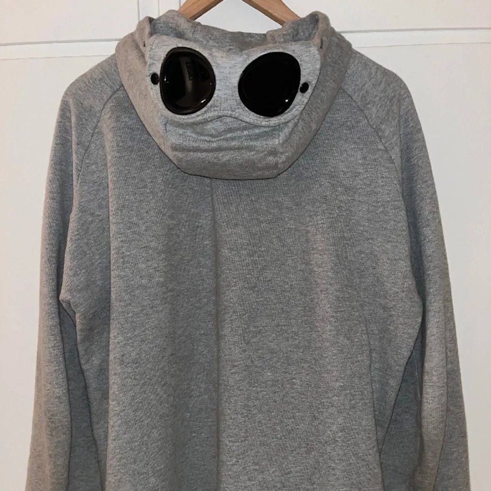 Grå zip hoodie från CP Company i storlek M. Hoodien är så gott som ny och är endast använd ett fåtal gånger. 10/10 skick. Pris kan diskuteras och tveka inte på att höra av dig vid andra frågor.  Nypris: 2700kr. Hoodies.