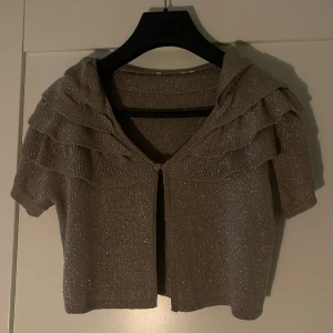 Guldig glittrig bolero - Bolero, står inte storlek men passar S/M. Lägsta pris 300kr