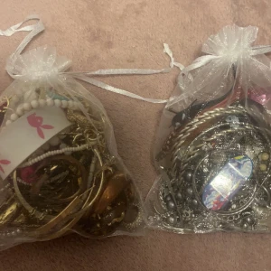 Goodiebag - Tre påsar fyllda med smycken och berlocker. Endast sorterat i silver och guld så vissa saker är i sämre skick än andra. 50kr per påse 