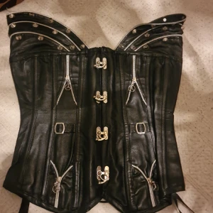 Läder korsett (PRIS KAN DISKUTERAS) - Skitsnygg läderkorsett med nitar!! Har behållt denna i hopp om att den ska hitta ett bra hem men det har helt enkelt bara inte hänt. Den är nog en Medium/XL beroende på kroppen. Köpt second hand så priset kan diskuteras.
