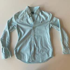 Turkos polo Ralph lauren - Turkos polo Ralph lauren skjorta i väldigt bra skick, använts nästan aldrig. Slim fit / strl S. Skön sommar /vår skjorta