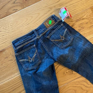 Lågmidjade utsvängda jeans  - Ett par snygga lågmidjade, utsvängda jeans. Köpte de på vinted men säljer då de är för små 🫠, har fortfarande kvar prislappen, så oanvända.   Mått:  Midja: 34 cm  Innerbenslängd: 81 cm  Total längd: 100 cm  Benvidden längst ner: 22 cm