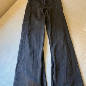 Grå jeansbyxor - Ett par grå/svarta jeansbyxor i bra skick. Byxorna har en klassisk femficksdesign och är tillverkade av denim. De har en rak passform och är bekväma att bära.