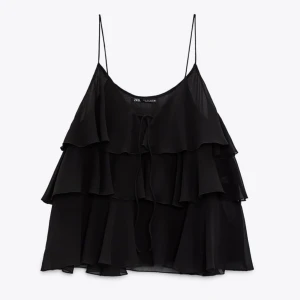 Zara topp  - Säljer den skitsnygga svarta topp med volanger och knytning vid bröstet. Använd cirka 3 ggr. Skriv för fler frågor!