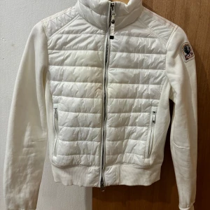 Vit fleecejacka från Parajumpers - En vit fleecejacka från Parajumpers med dragkedja framtill och två fickor med dragkedja. Jackan har en quiltad design på framsidan och en hög krage.