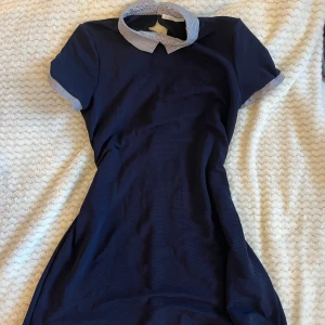 Marinblå klänning - Marinblå klänning med krage och detaljer på ärmarna. Använd en gång, köpt secondhand. Strl S-M