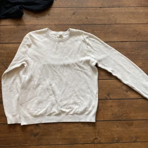  stickad tröja från East West - En vit/ ljus beige stickad tröja från East West med rund halsringning och ribbstickad kropp. I fint skick!