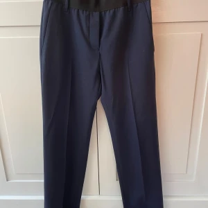 Acne Marinblå byxor  - Marinblå byxor med pressveck från Acne. Svart bälte i midjan. Storlek 36. 