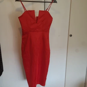 sexig klänning  - supersnygg röd klänning med fin detalj vid brösten och dragkedja i ryggen. klänningen går en bit över knäna på mig som är 160 cm lång 