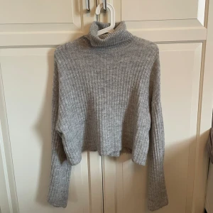 Grå stickad tröja  - En grå stickad polotröja från H&M, använd men i fint skick☺️ tröjan är lite kortare och croppad i modellen