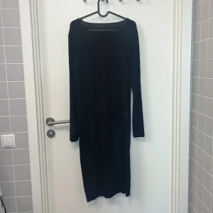 Klänning - Svart tight långklänning, går ca 7cm nedanför knäna på mig (174cm lång). 