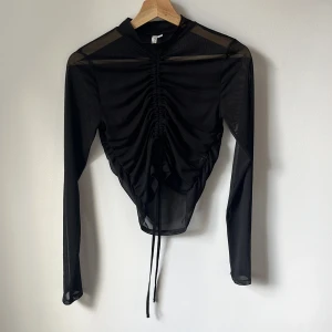 Genomskinlig/mesh tröja NLY TREND - Tröja i mesh från Nelly Trend. Långärmad med dragsko fram. Högre hals. Supersnygg men för liten tyvärr 🖤