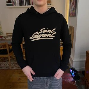 Saint Laurent hoodie  - Saint Laurent hoodie i bra skick, saknar snören.  Modellen på bilden är 175cm, står S/175/92A som storlek på tvättlappen men anser att den är mindre än det. Passar den som vanligtvis har XS eller XXS. Skriv privat för fler frågor.