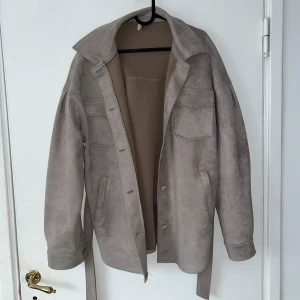 Grå kort kappa  - Jackan är i storlek s, bra skick 