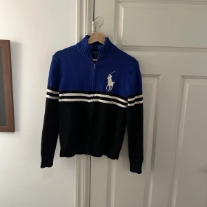 Ralph Lauren kofta - En väldigt fin polo Ralph Lauren stickad kofta. Den är speciell då det inte är så många som har denna eftersom att den såldes i USA endast. Det är storleken M Men passar S. Kontakta vid minsta lilla fråga eller fundering. 