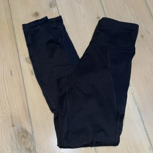 Träningstights  - Högmidjade träningstights med meshdetaljer, snöre och fickor på sidorna (t.ex mobilen får plats). Köpt för flera år sen men i mycket fint skick! 