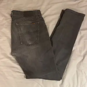 Nudie jeans i en väldigt snygg tvättad svart färg. Skick: 6,5 då de har ett hål på knät men som ändå gör jeansen lite snyggare! Nypris: 1600kr. Killen på bilden är 182cm lång. OBS är öppen för byten! 