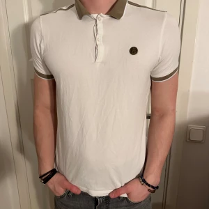 Vit Massimo Dutti Polo Pikétröja - Stilren Vit Massimo Dutti Polo Pikétröja i grymt skick! Storlek M men passar även som S. Modellen är 182 cm och väger 75 kg. Pris går ej att diskuteras!