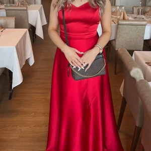 Röd balklänning  - Säljer nu min balklänning som enbart använts en kväll.   Klänningen är i nyskick.   Storleken är 42 men passar både 40 och 38, möjligtvis 44 pga de justerbara banden på ryggen.   Jag är 168 cm lång, skriv gärna för tydligare bild på längden. 