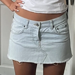 Ljus jeanskjol lågmidjad  - Midja: ca 80 cm Längd: 25-28 cm 