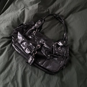 Glansig handväska - Aldrig använd. Köpte vintage men ser ny ut. Glansig och tål vatten. 