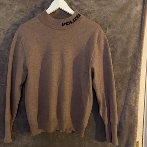 Långärmad polo med tryck - Cool långärmad, ganska varm tröja. Grålila färg. Storlek S-M beroende på hur man vill att den ska sitta. Kommer inte till användning.