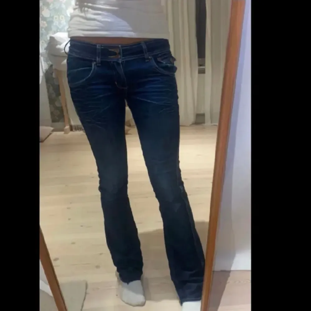 Säljer dessa mörkblåa lowwaist utsvängda jeans med snygga fickor där bak!. Jeans & Byxor.