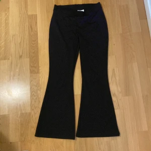 Svarta flared pants - Svarta flared pants i jätte bra skick. Har endast använts ett par få tall gånger. De är 96cm långa och innerbenet är 69cm. Priset kan alltid diskuteras 
