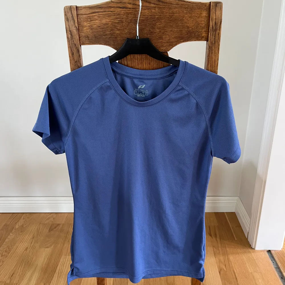 En blå tränings tröja i storlek M, skulle säga S. T-shirts.