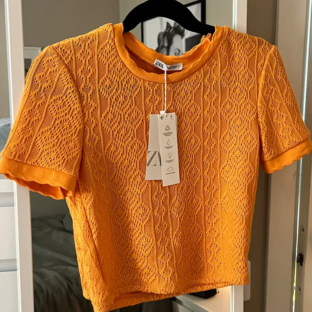 Virkad/stickad tröja från Zara, helt oanvänd med prislapp kvar och säljs inte längre då den köptes 2022. Assnygg till sommaren med en bränna och jeansshorts🧡🧡lägg gärna prisförslag!. T-shirts.