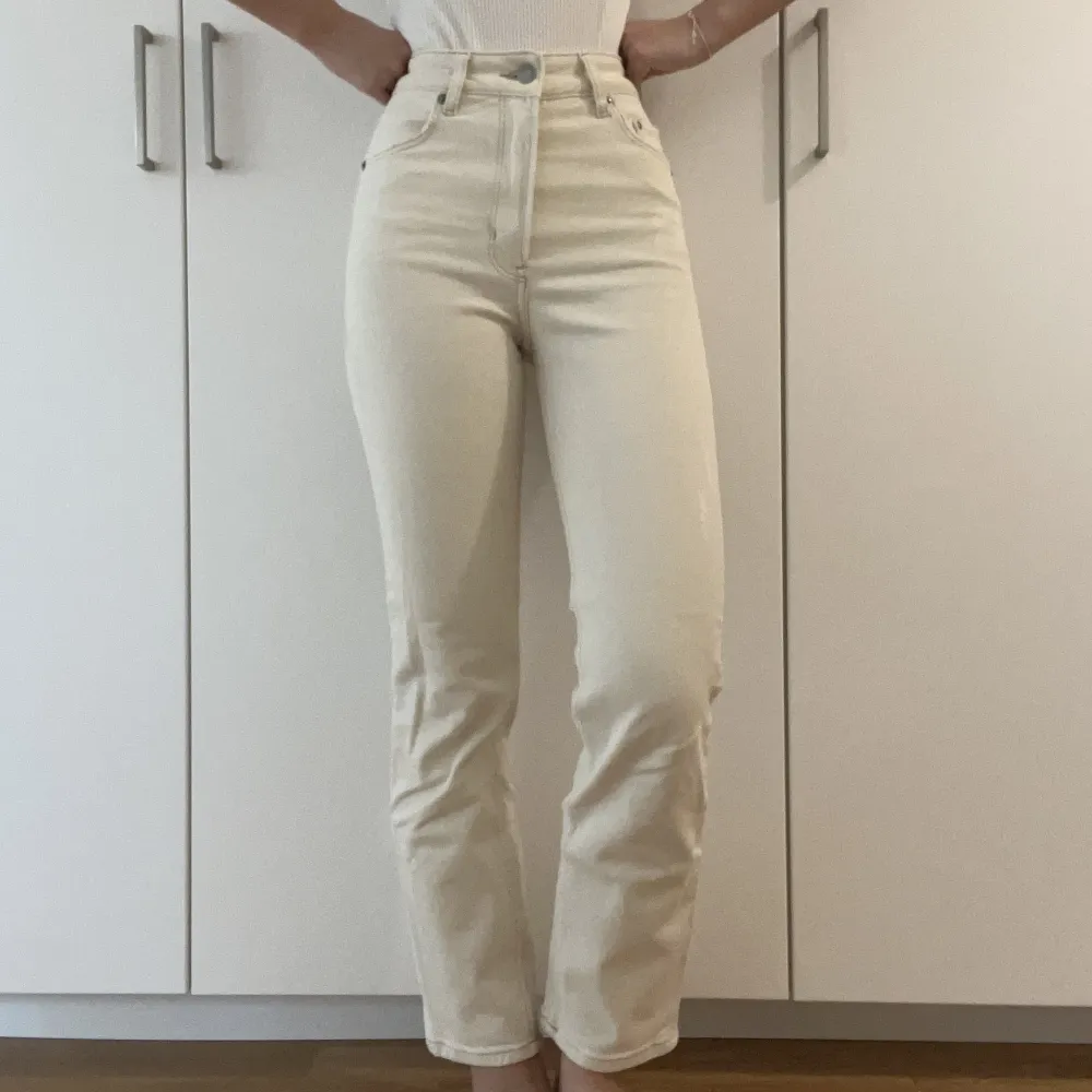 Ett par krämvita straight-leg jeans med hög midja, köpta från H&M. I storlek EU32 med vanlig-passform. Inte speciellt använda, väldigt fina men blev utrensade i vårstädningen. Bara höra av dig för mer info! :). Jeans & Byxor.