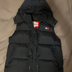 Tommy Hilfiger väst - Säljer min feta Tommy hilfiger väst som är köpt i Lausanne Schweiz. Den har en liten skada vid ena ärmen (se bild 2) men inget som syns när den är på. 7/10 skick Kostar runt 2000-2500kr i nypris  Mitt pris 1000kr går att diskutera Tveka inte vid frågor!!